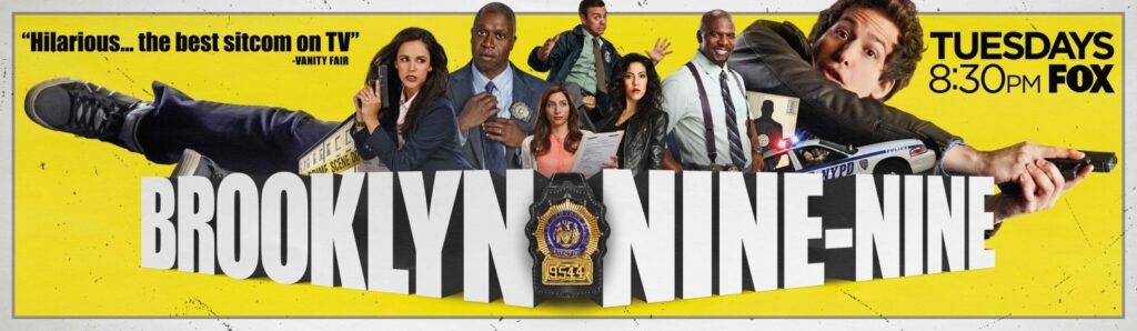 Brooklyn Nine-Nine cast photo with Andy Samberg and the squad in their police uniforms.